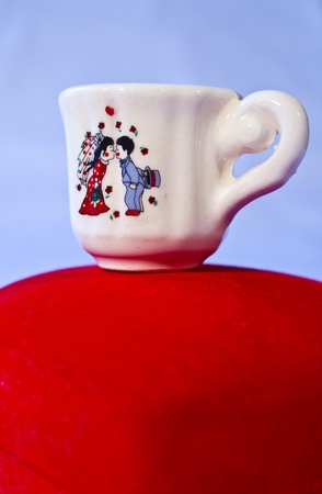 Cup has a little gift and wedding couples stuck.の写真素材