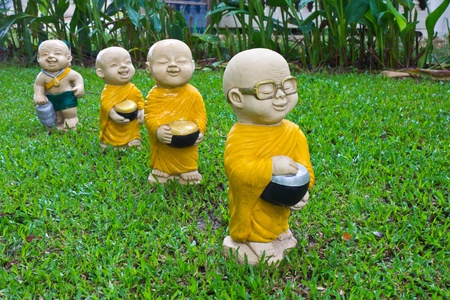 The stucco temple boy with monks was walking on the lawn.の写真素材