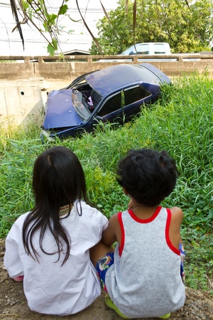 Children watching a car accident, car drove into some bushes. の写真素材