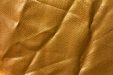 Surface has a wrinkled golden cloth and reflection of sunlight の写真素材