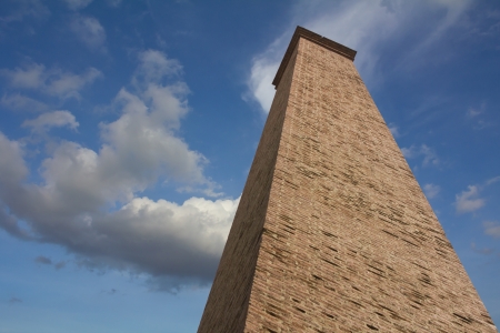 Rectangular brick chimney, which are large and very high on a cloudy sky background の写真素材