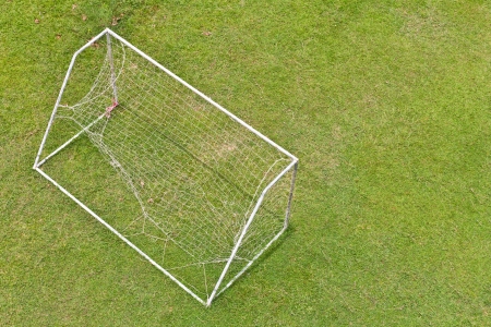 View above the goal nets torn badly beaten in a green grass 