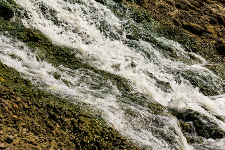 Close up of a waterfall that flows into a concrete wall stone.の写真素材
