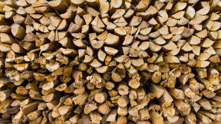 Background of a small pile of firewood logs stacked more.