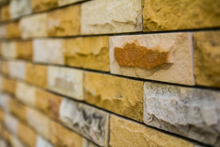 Close up of an old brick different from those of its side walls blur.