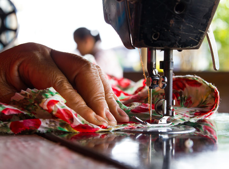 Close-up of women with old sewing machine stitch fabric beautiful flowers.の写真素材