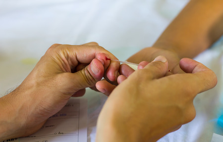 Close-up of blood on the finger of the patient, which can lead to disease.の写真素材