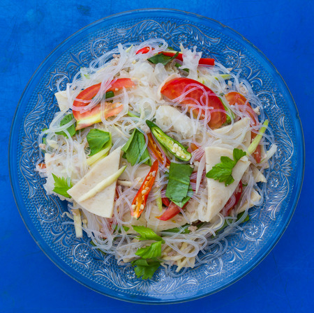 Isolate above, spicy vermicelli cooked crispy sliced pork put up a simple blue background.の写真素材