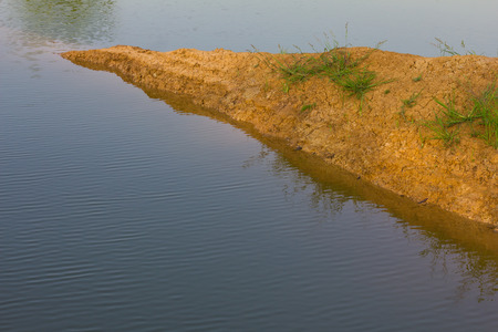 Close background soil surface dry above the water surface of the pond farmers.の写真素材