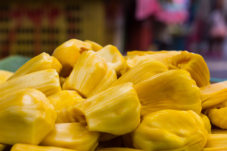 Jackfruit yellow seedless pile on green banana leaf tray for sale in the market place.