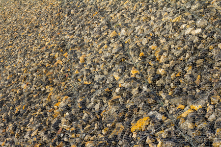 Wall rock dam which has many large steel wire mesh covering to prevent water erosion.の写真素材