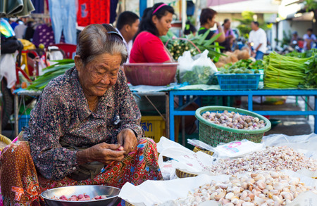 PHICHIT THAILAND-JUNE 19:
Elderly Woman aging of Thailand, which is still trading, onion and 
garlic in a vegetable market on the road happily.On June 19, 2015 
in Phichit, Thailand.のeditorial素材