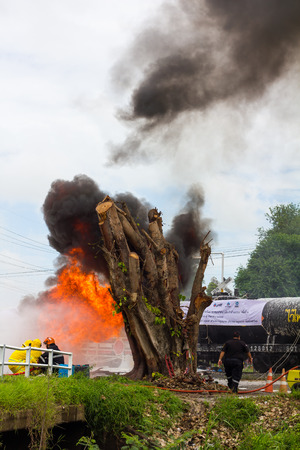 PHIcHIT THAILAND-AUGUST 7:Team Thailand firefighters extinguished the blaze, flames, smoke close to the train tanker, which is dangerous.On August 7, 2015 in Phichit, Thailand.のeditorial素材