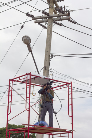 PHICHIT THAILAND-AUGUST 7:Photographer climb up the scaffolding steel pole near high voltage can be dangerous.On 
August 7, 2015 in Phichit, Thailand.のeditorial素材