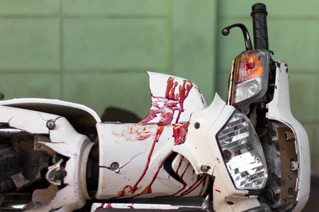 Close up the front mudguard white blur motorcycle with blood and broken headlights of an accident.の写真素材