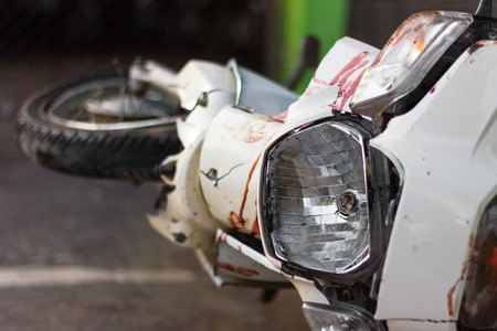 Close up the front mudguard white blur motorcycle with blood and broken headlights of an accident.の写真素材