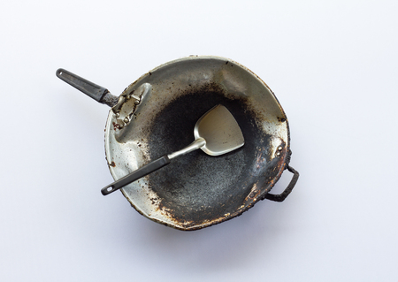 Isolates old pan which has been used for a long time, which is filled with grease, rust and dirt.の写真素材