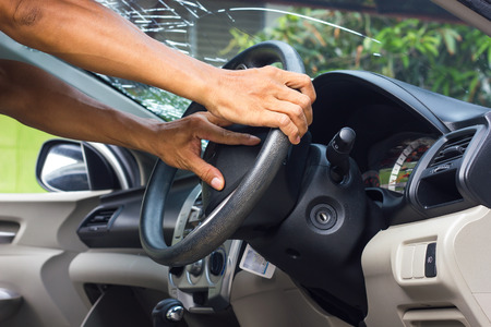 Hand of a man standing and holding the steering wheel in the car accident which fractured...