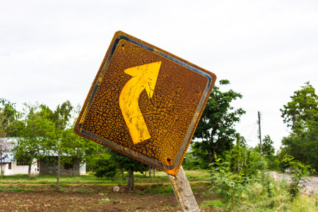 Right turn traffic signs, which have weathered old rusty set tilt on rural roads.の写真素材