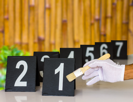 Hands of the forensics are dusted with a brush at the scene to determine the number pad with a bamboo background.の写真素材