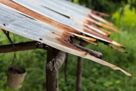 Close beside the cottage where the old zinc roof dented and rusty grass beneath.の写真素材