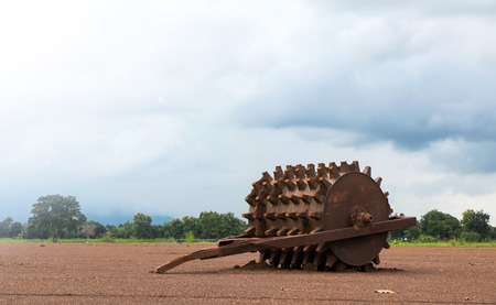 Steel wheels, a piece of rollers abandoned gravel laid on the ground in rural Thailand agriculture.