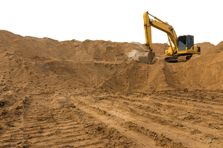 Loader backhoe parked there on the mountain, which has a large pile of sand in the wheel tracks below.の写真素材