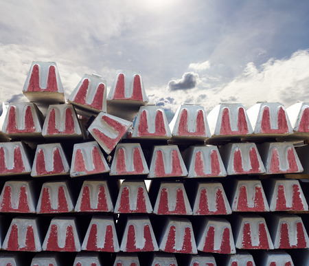 Background with concrete pole post with red U-shaped sign, stacked with clouds, sunlight, sky as the backdrop.の写真素材
