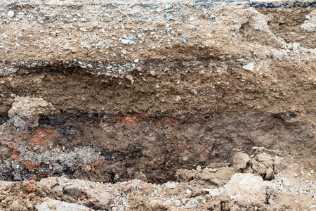 Close-up backgrounds, walls, surfaces, cuttings, soil layers and stones under the road, which are dug for construction.の写真素材