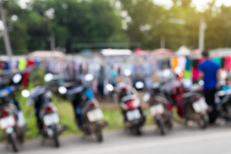 The background blurred at the rear of a motorcycle parked in rows in a Thai rural market.の写真素材