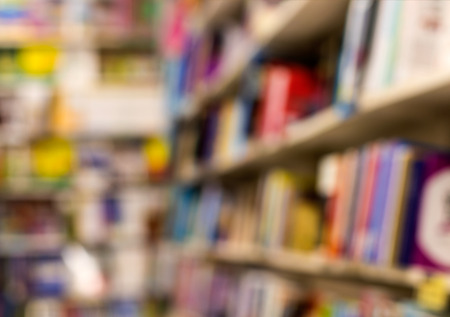Close-up blurred background The rows of many books are placed on a panel in a bookstore.