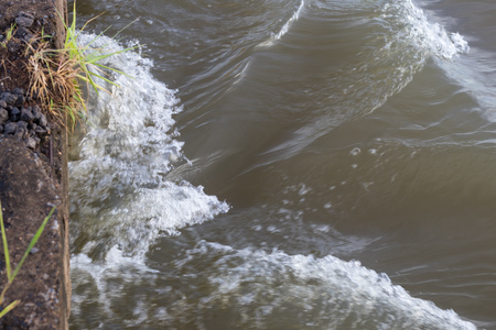 Close-up of a flooded stream under a cement bridge in Thailand may cause damage.