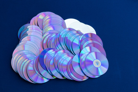 Old DVD backgrounds are used to reflect the colorful colors stacked over the blue cloth.の写真素材