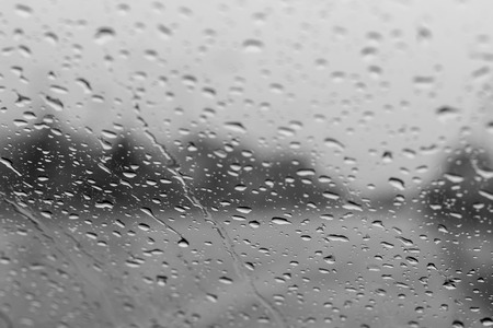 Close-up shots blur the monochrome background, droplets of rain on the windshield, looking from the inside to the country road.の写真素材