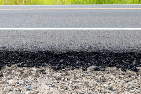Close-up details of new asphalt pavement surface onto the pebbles to improve repair.の写真素材