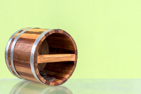 Close-up of small wooden buckets Ancient patterns with coins falling on glass floor with green concrete walls as backgroundの写真素材