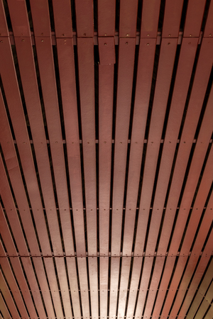 The view from below is the background of the brown wooden ceiling, which is broken with the soft light shining through.の写真素材