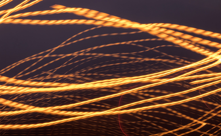 Abstract background, light lines of yellow lanterns on a circular street, swirling, scattering in...