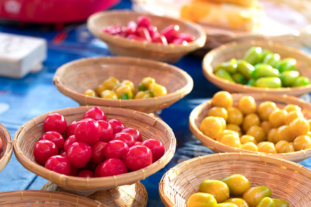 Plated balls, which are brightly colored on a small, beautiful weave bamboo basket, are commonly found in the market.の写真素材
