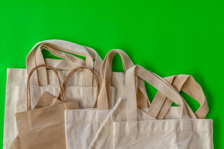 Background of many cloth bags which are overlapping with small paper bags with green color as the scene.の写真素材