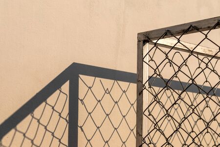 Close-up of the frame, the metal frame, the grille with sunlight and shadows, which stretches over...