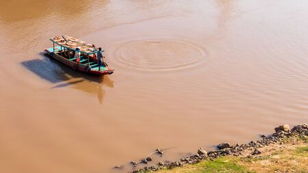Top view A Thai fisherman stood on a boat to catch fish on the river, near the rocky coast and the...