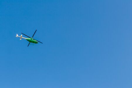A view from below, green helicopters flying in the sky during the day time.の写真素材