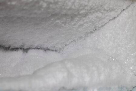 Close-up of many ice crystals in the freezer of an old refrigerator that was abandoned and damaged.