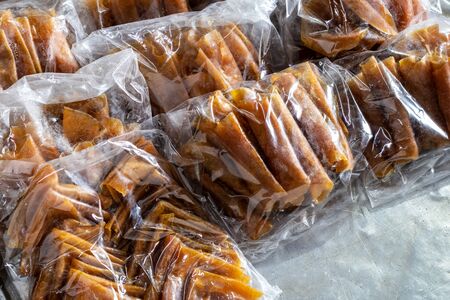 Mango stir-dried, then rolled and folded into many plastic bags, which is a common food preservation during the dry season of the Thai countryside.の写真素材