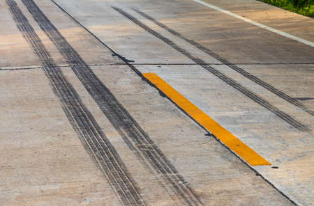Background of black tire traces. Braking and stopping of truck wheels on concrete road surfaces in rural Thailand.の写真素材
