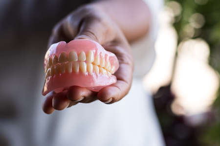 Close-up of a denture in the hand of a Thai elderly woman, protruding to show its appearance.の写真素材