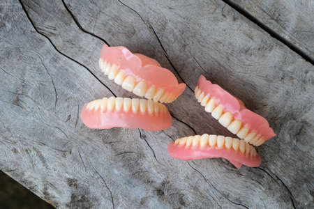 From above, close-up, the two dentures were left open on the floor of an old wooden table.