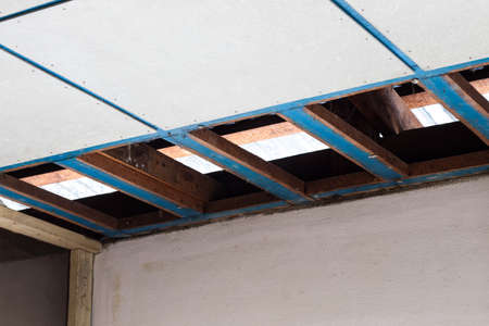 Close-up, dismantling, repairing the old ceiling panels and wooden frames of a house in preparation...