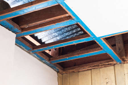 Close-up, dismantling, repairing the old ceiling panels and wooden frames of a house in preparation...